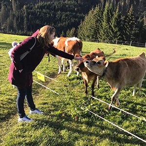 Janien streichelt Kälber auf einer Alm